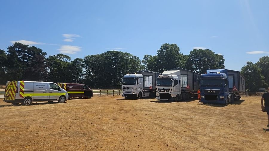 CaraNation trucks and escort van lined up at a holiday park