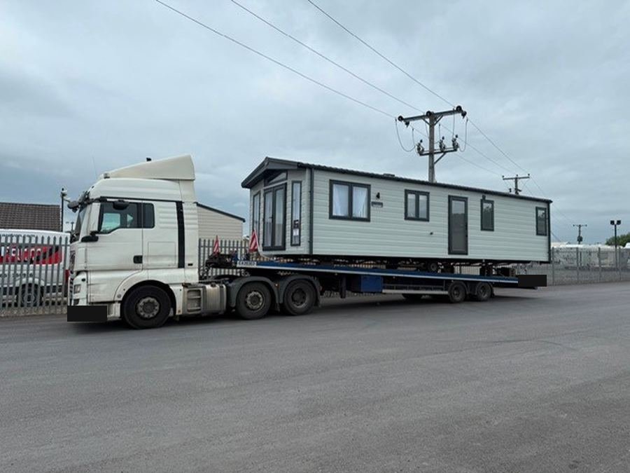 Lodge on a low-loader on an industrial estate